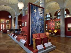 A room in a museum with paintings and art