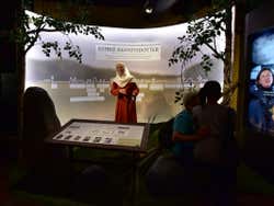 A museum exhibition of a woman in a red dress